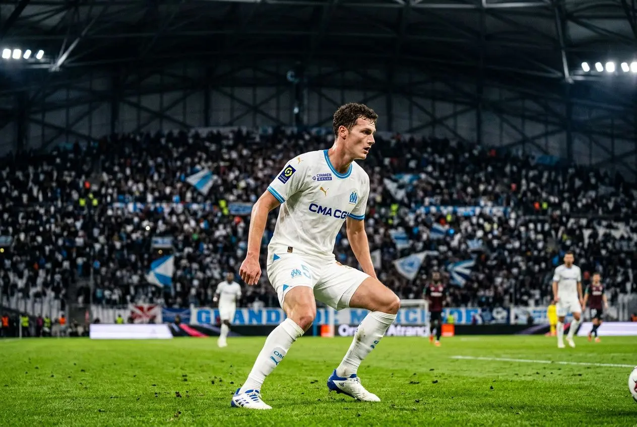 Joueur Benjamin Pavard en action sur le terrain, vêtu d’un maillot blanc, en déploiement lors d’un match, dégageant concentration et tactique. analyse match pavard.