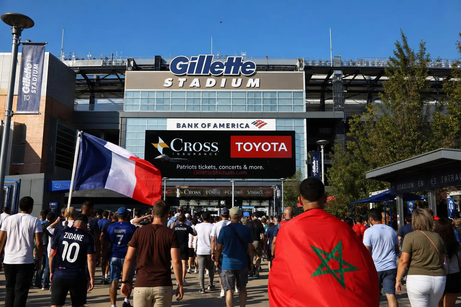 Entrée au Gillette Stadium avec des fans portant des drapeaux France et Maroc pour le match France Maroc coupe du monde 2026, ambiance de quart de finale.