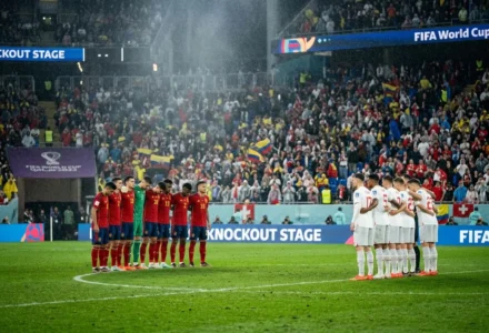 Homme en rouge et équipes nationales alignées avant le coup d’envoi, Suisse et Colombie en formation sur le terrain de football. suisse colombie statistiques matchs intégrée ici?