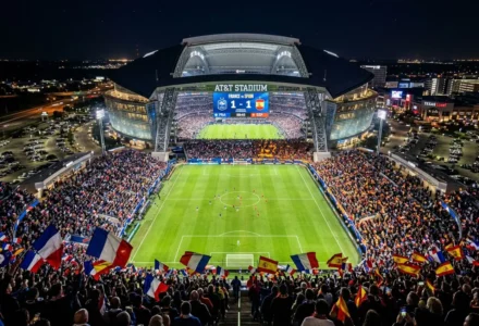 Stade AT&T nocturne plein de drapeaux aux couleurs des fans, terrain de football éclairé et public enthousiaste pour un match Espagne-France. prédiction france espagne match intégrée.