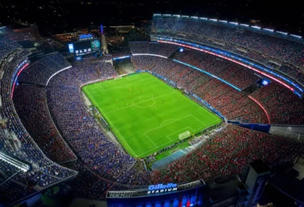Stade bondé lors d’un match de football nocturne, vue aérienne du terrain vert entouré de tribunes remplies, ambiance intense pour une rencontre France-Maroc. analyse france maroc football