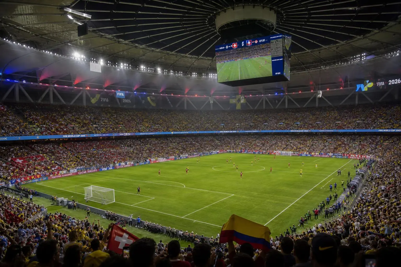 Stade plein pour Suisse-Colombie, vue aérienne du match des 8es de la Coupe du Monde 2026, tribunes colorées et terrain vert au centre.