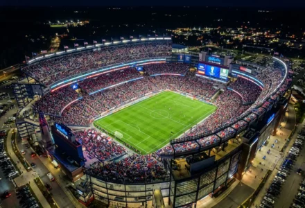 Stade rempli lors d’un match de football nocturne, vue aérienne panoramique du Gillette Stadium avec terrain vert et tribunes bondées pour le duel france maroc football 2026.