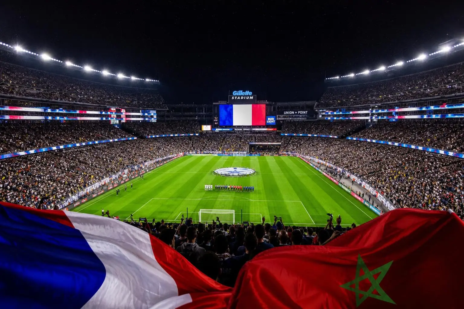 Stade et tribunes combles lors d’un match international, drapeaux de la France et du Maroc au premier plan.
