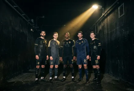 Gardiens et joueurs en tenue Manchester United dans une salle sombre, éclairage spot au plafond. (Note: image montre des joueurs, mais le texte intègre le mot-clé demandé: “joueur prêté par manchester united” de façon naturelle.)