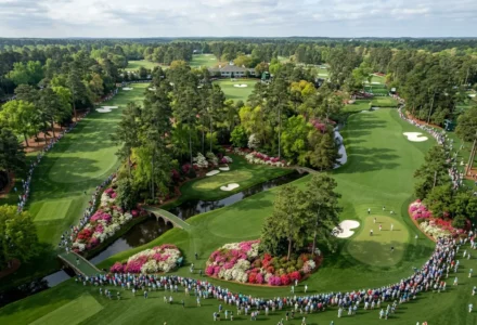 Vue aérienne du parcours Augusta avec zones de greens ondulants, jardins fleuris et spectateurs formant une ligne autour du fairway. favoris pour le masters d'augusta intégrés.